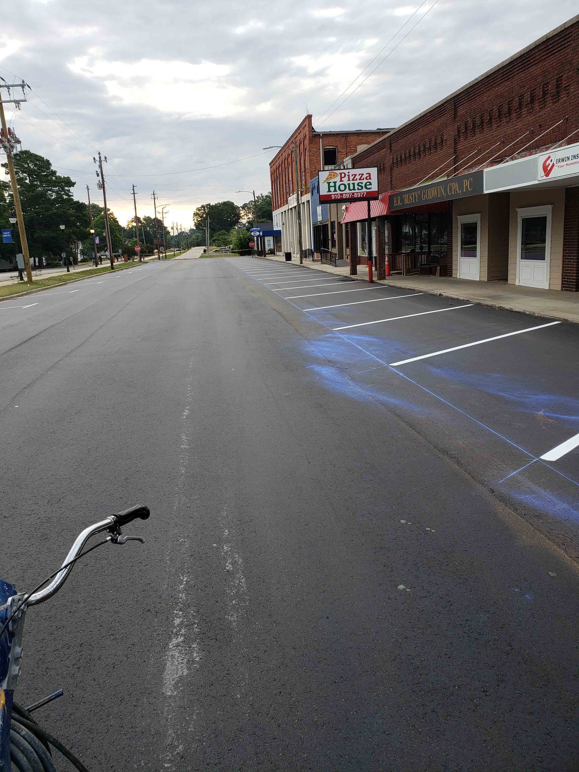 A bicycle is parked on the side of the road in front of a building that says ' castrol ' on it