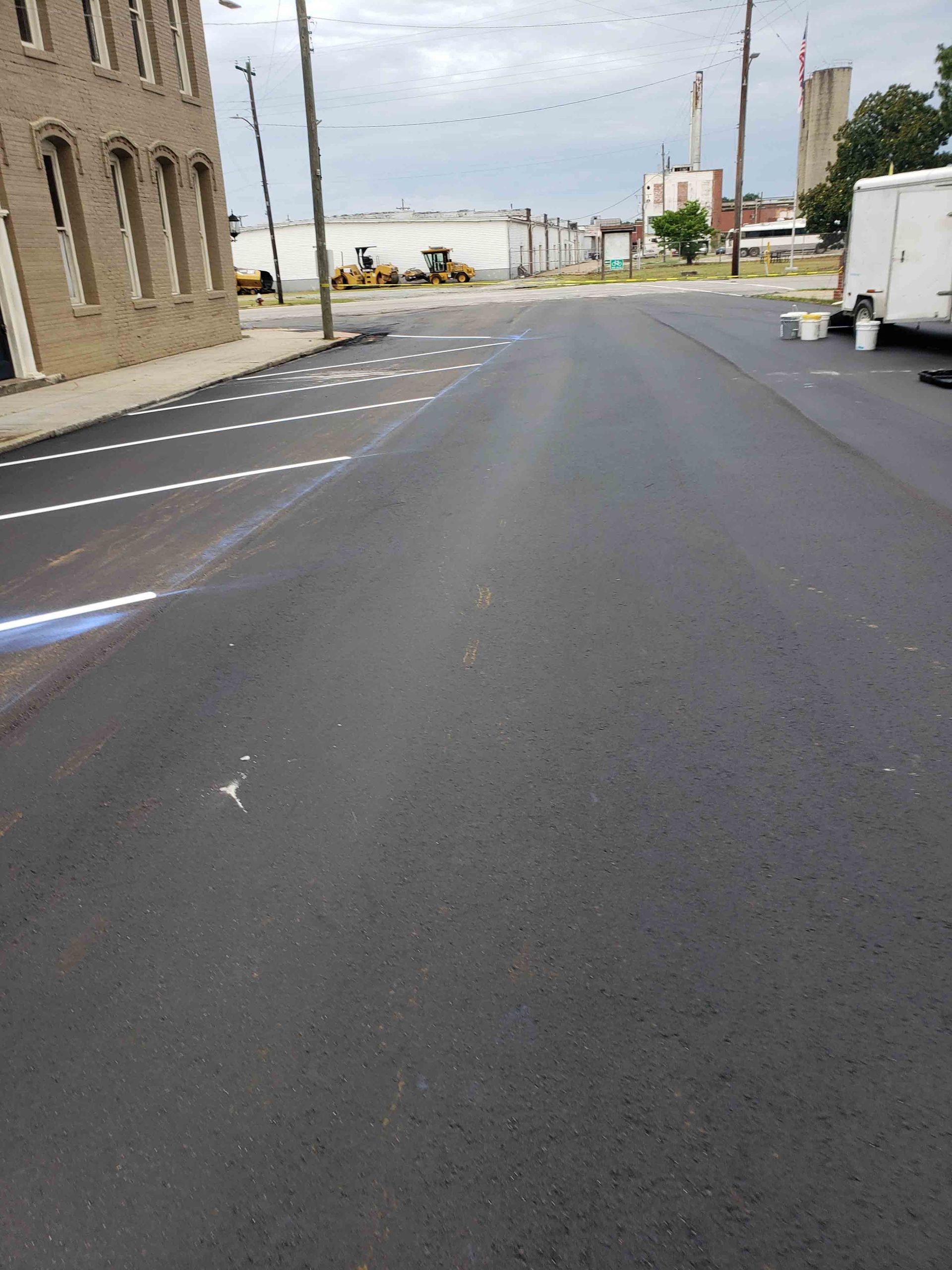 A street with a lot of parking spaces and a building in the background.