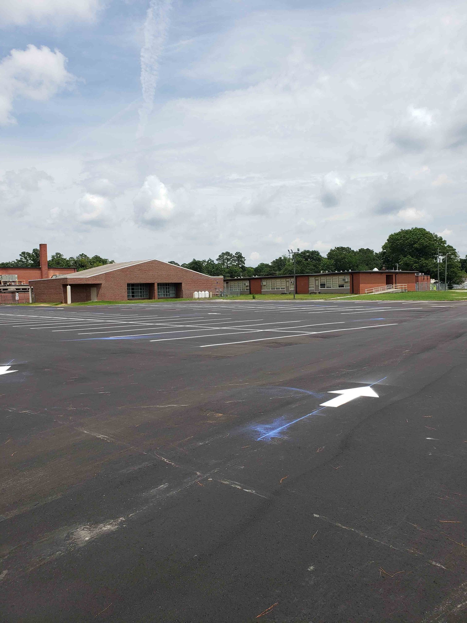 An empty parking lot with a brick building in the background.
