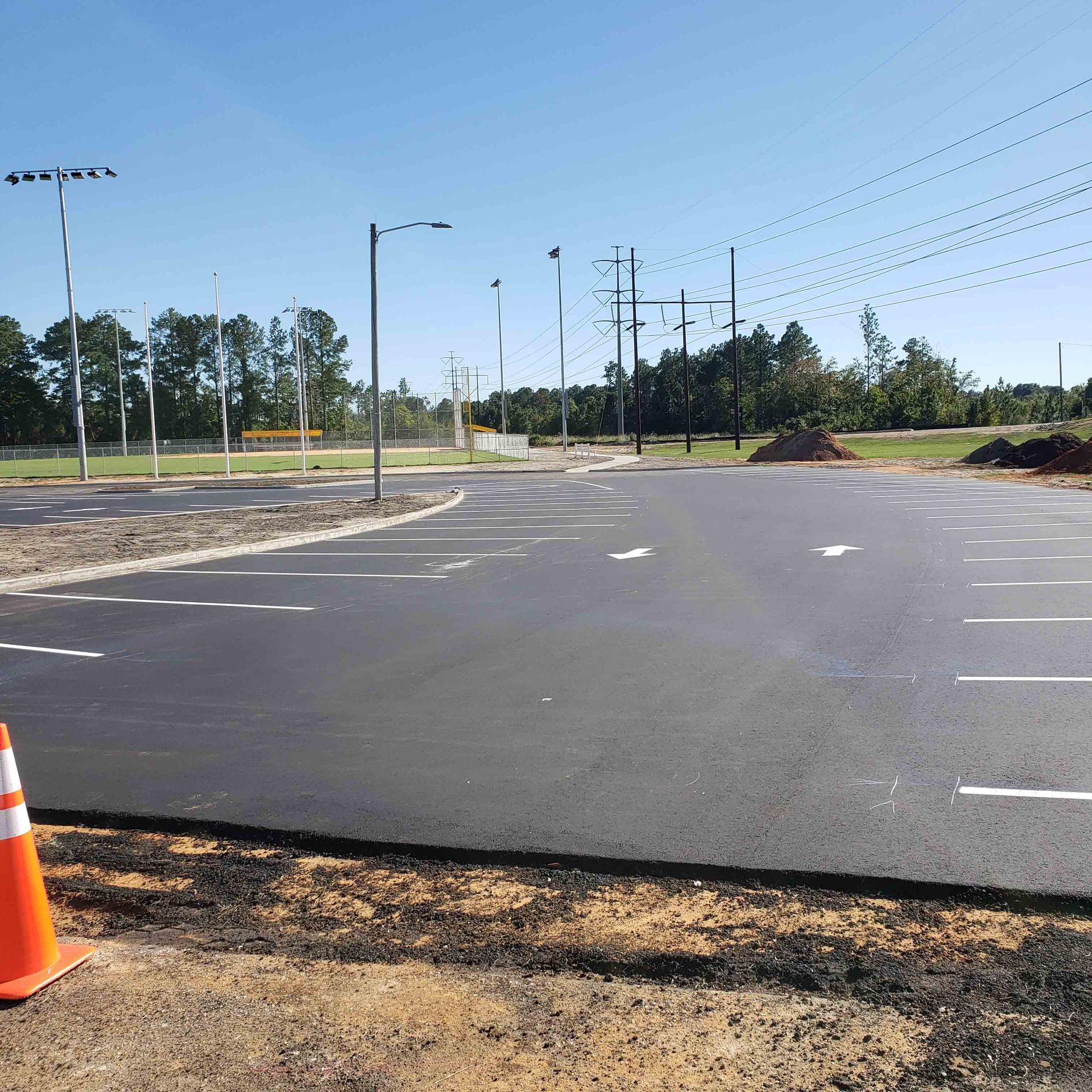 An empty parking lot with an orange cone in the foreground