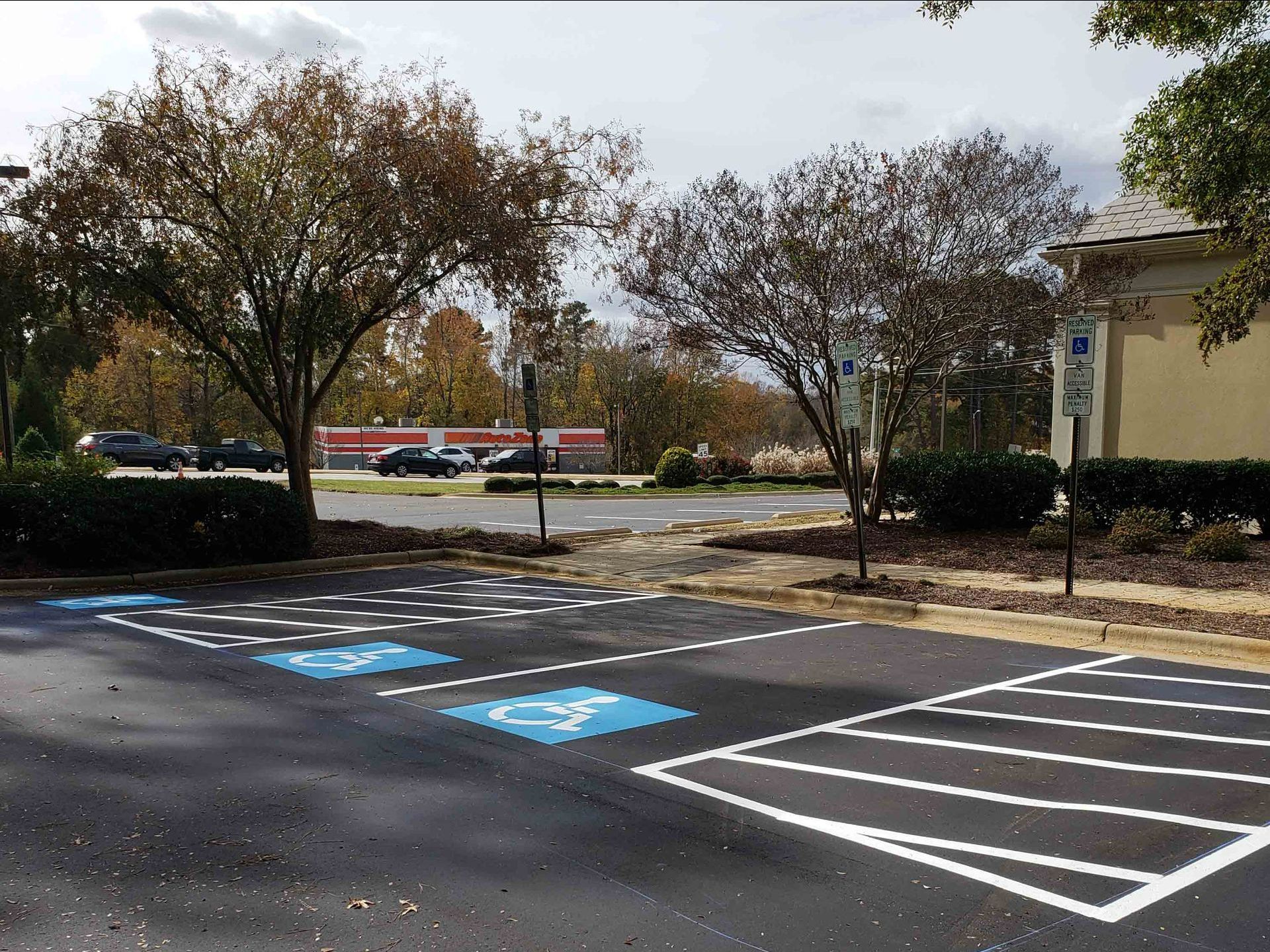 A parking lot with handicapped parking spots and a building in the background