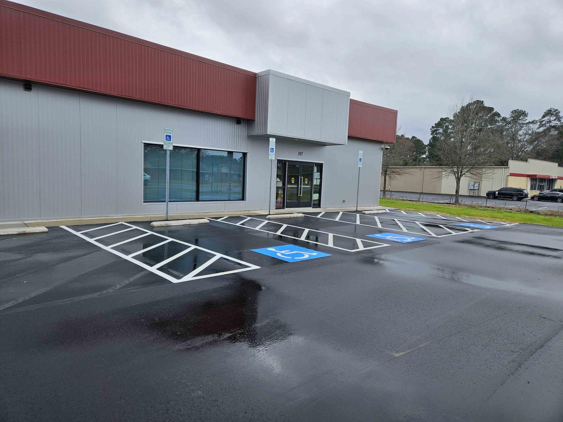 A parking lot in front of a building with a handicapped parking space.