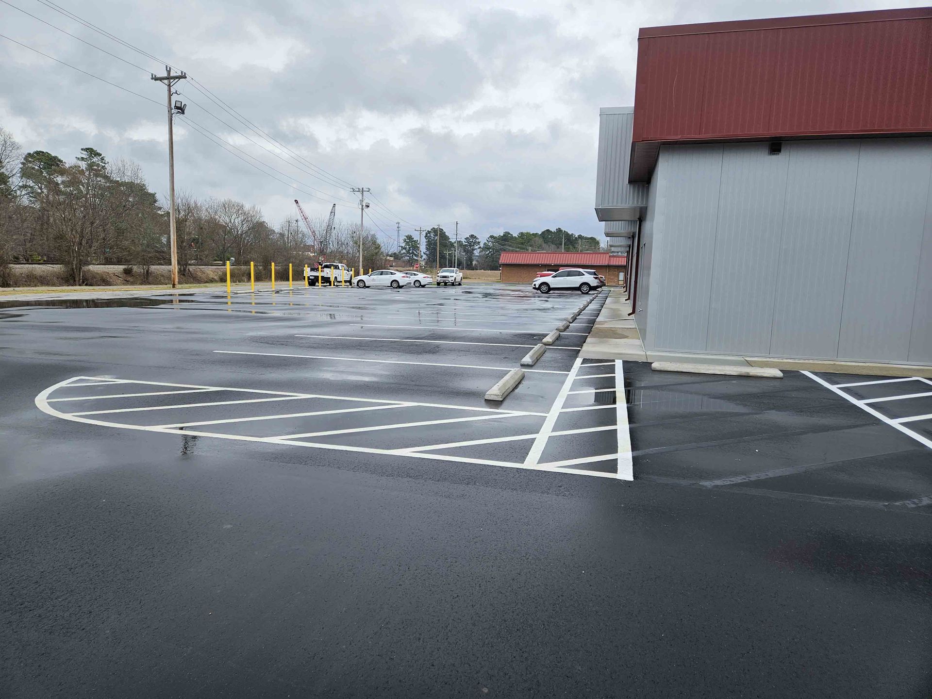 A parking lot with a red building in the background