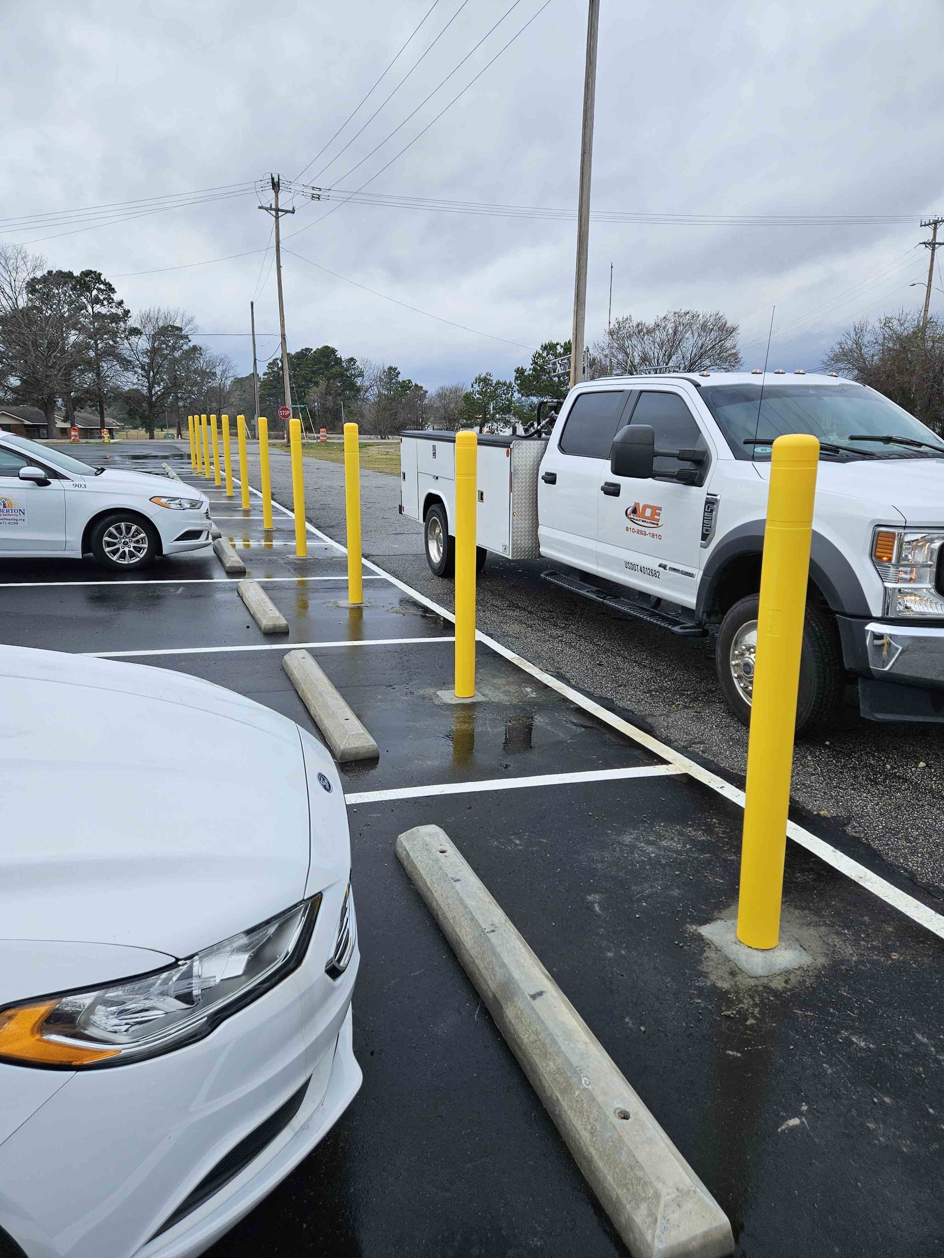 A white car is parked next to a white truck in a parking lot