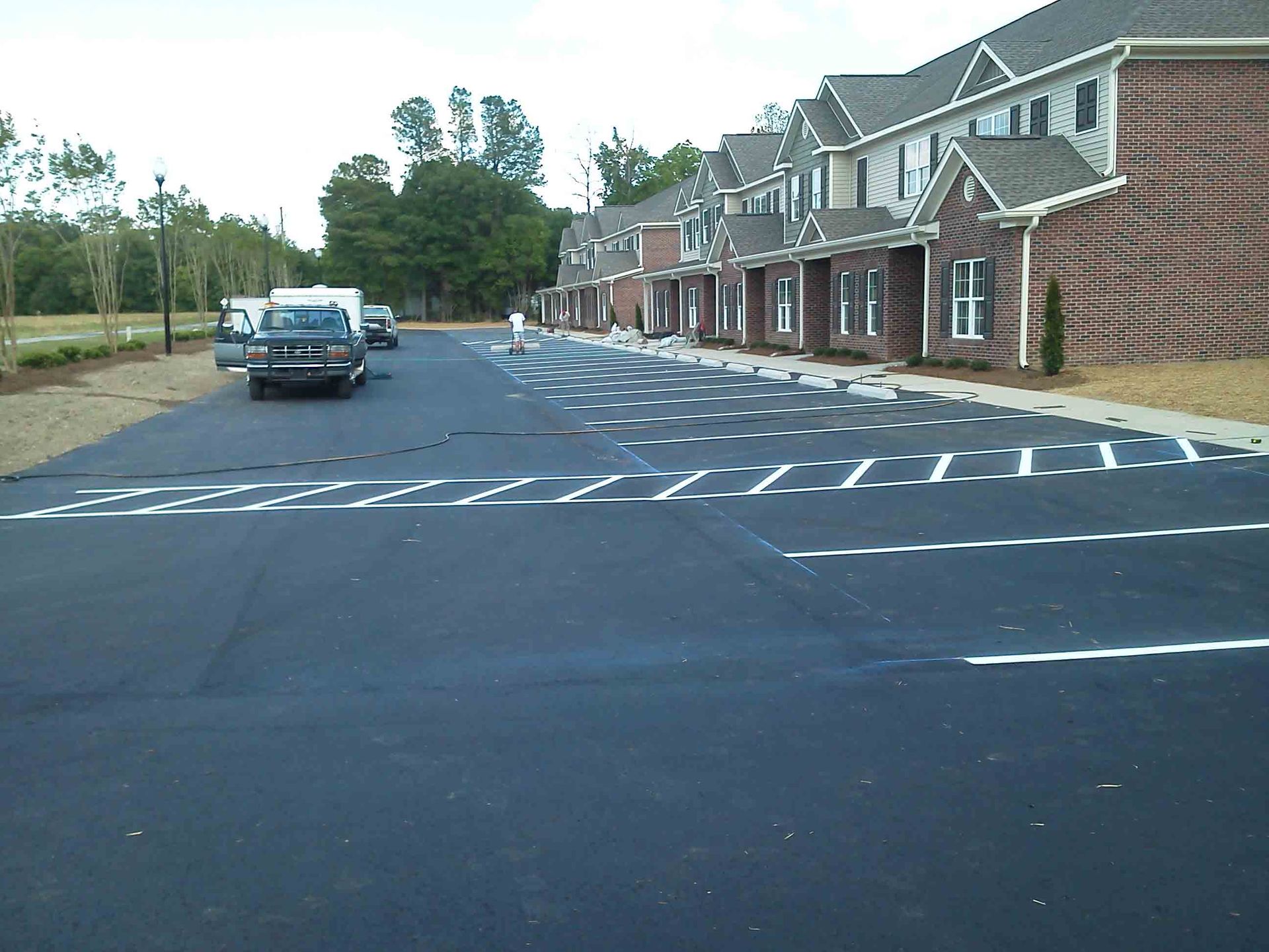 A truck is parked in a parking lot in front of a row of apartment buildings