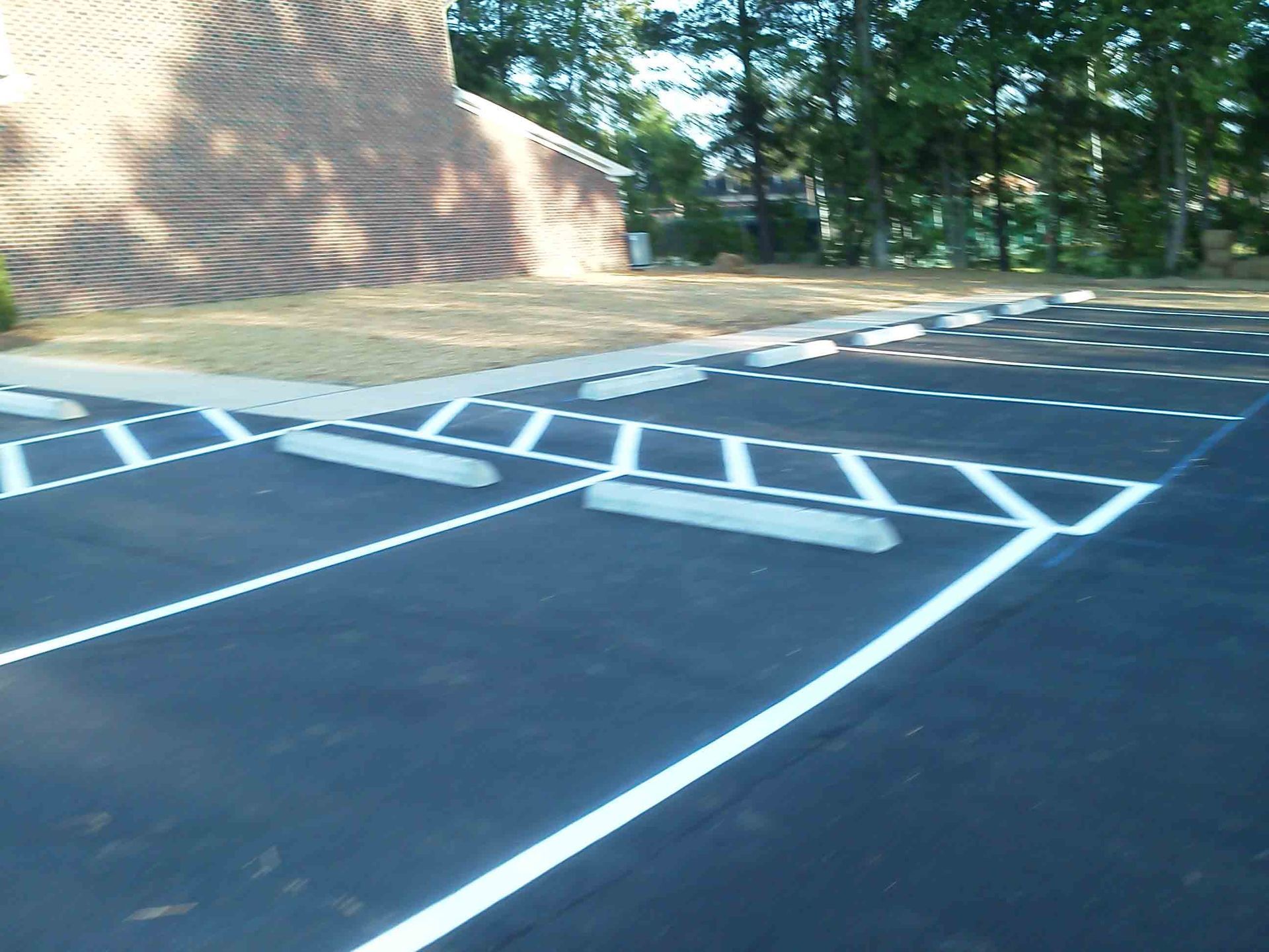 A parking lot with a brick building in the background