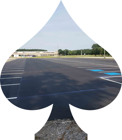 A spade symbol with a parking lot in the background