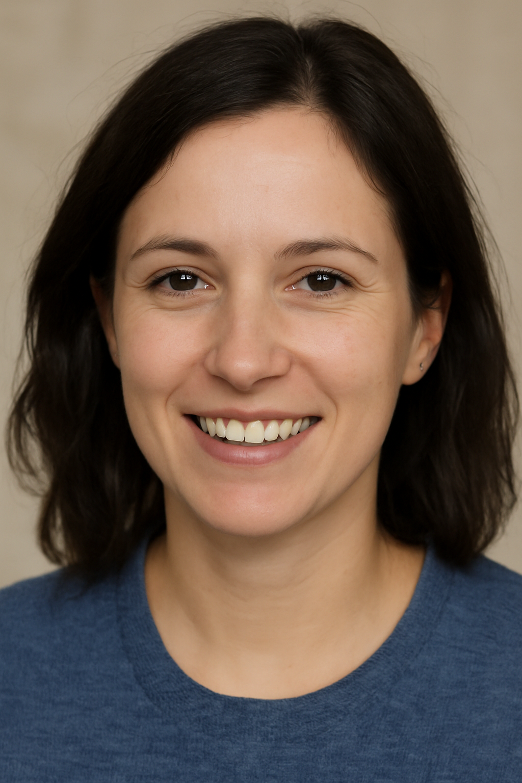 Une femme portant une chemise bleue sourit à la caméra