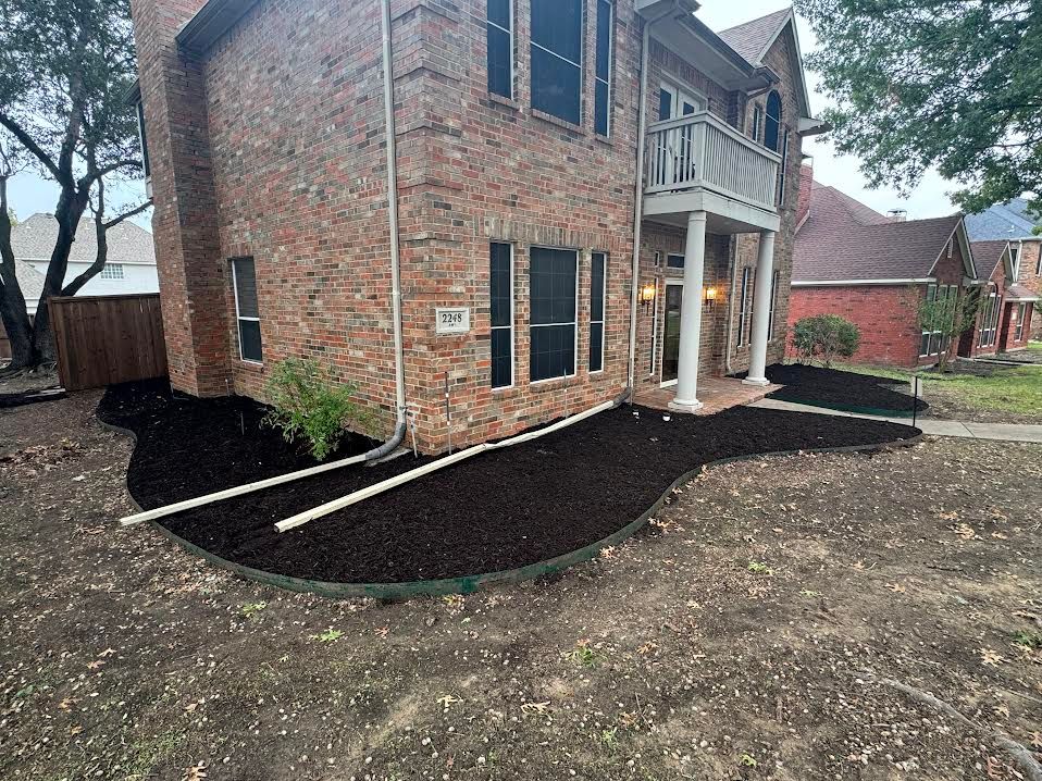 Brick house with dark mulch landscaping and a balcony.