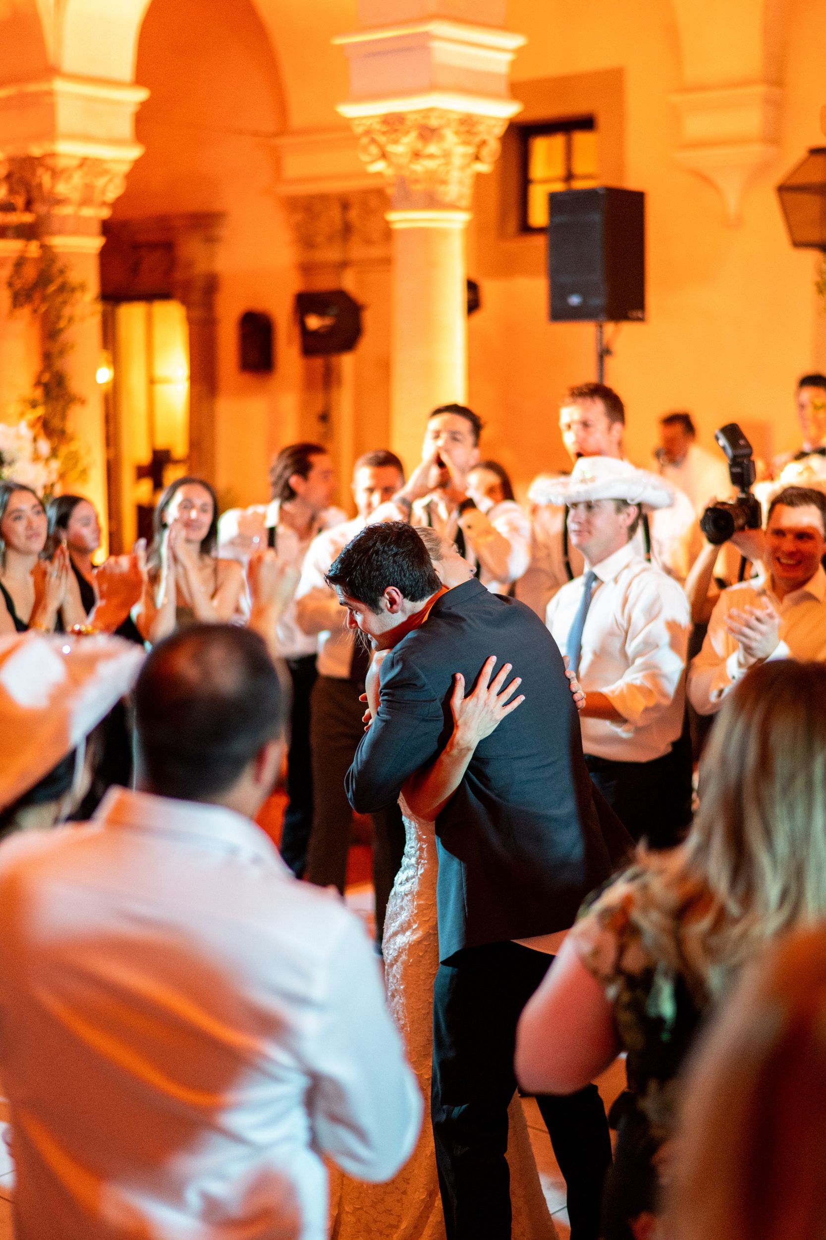 A group of people are dancing at a wedding reception.
