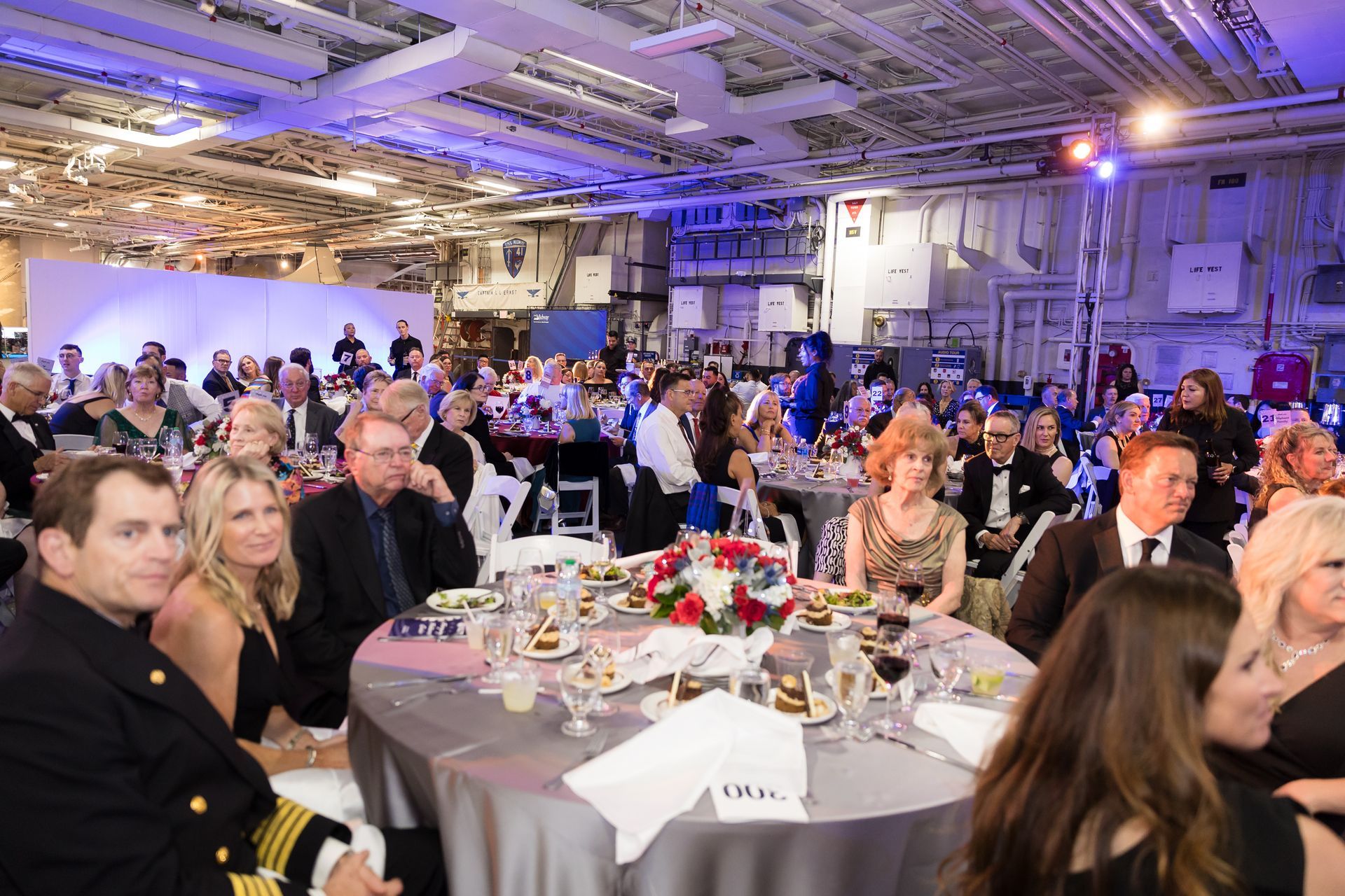 A large group of people are sitting at tables in a large room.