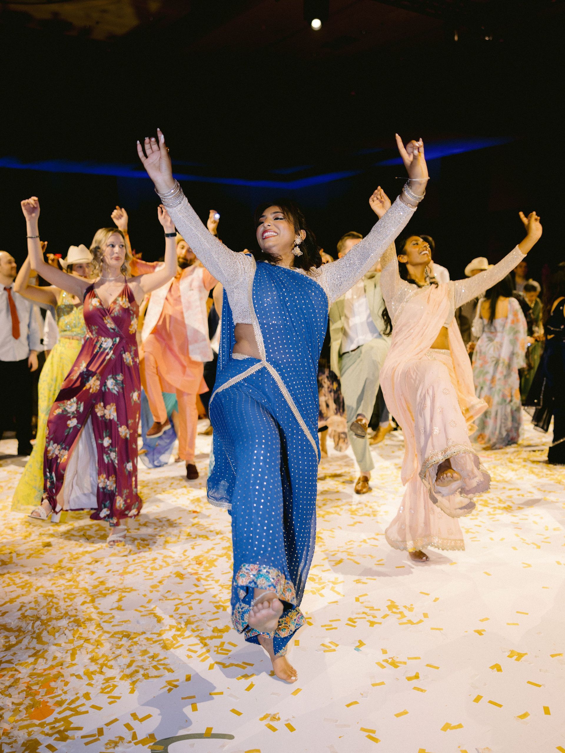A group of people are dancing on a white floor.