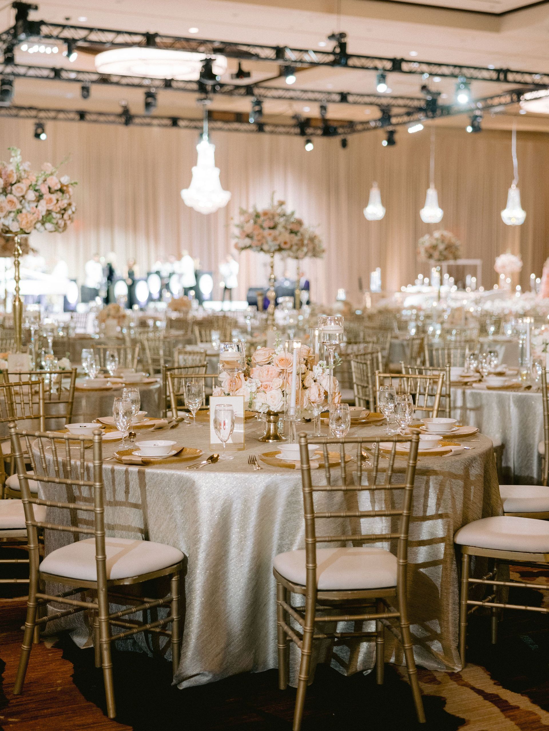 A large room with tables and chairs set up for a wedding reception.
