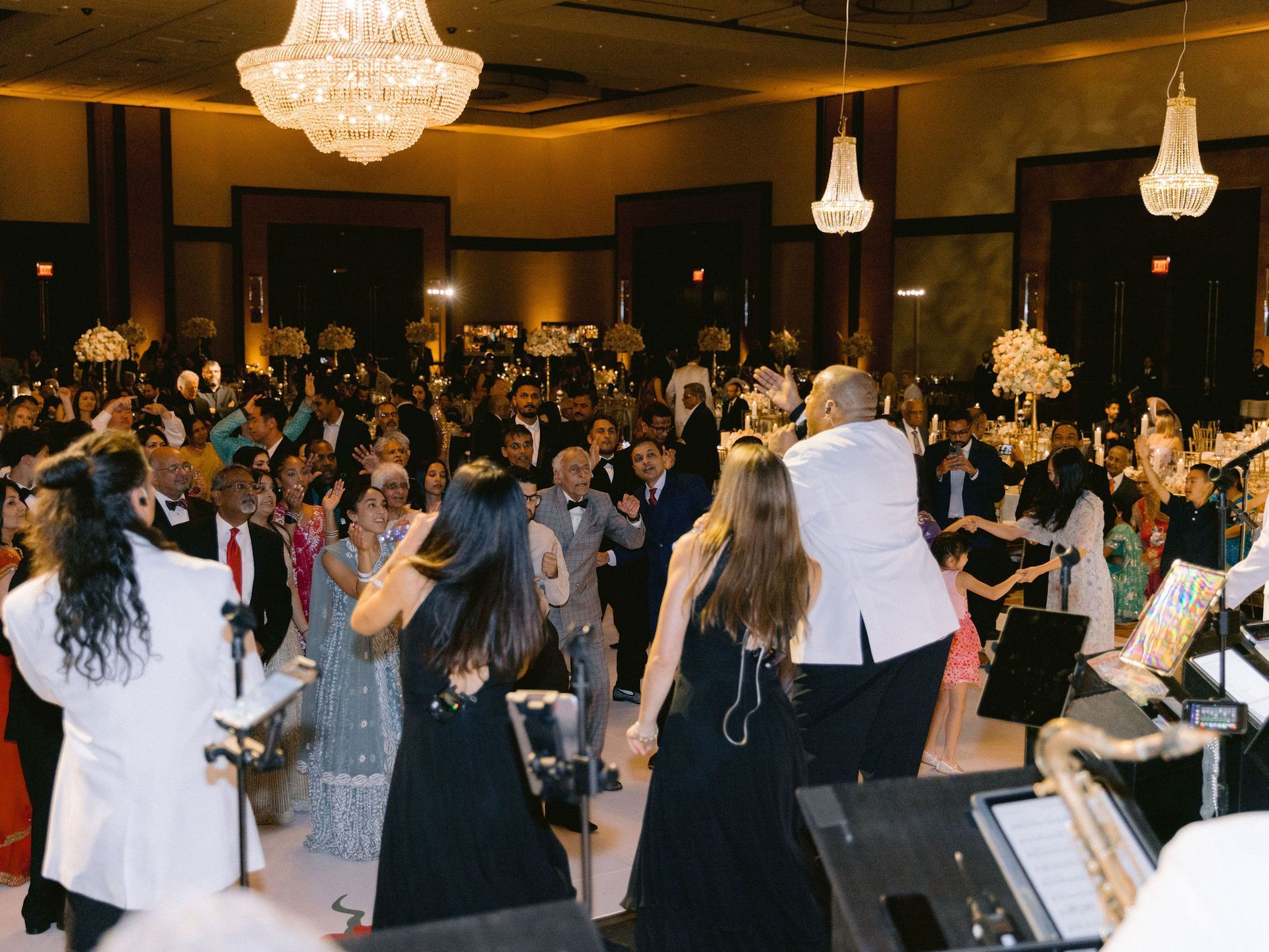 A large group of people are dancing in a large room