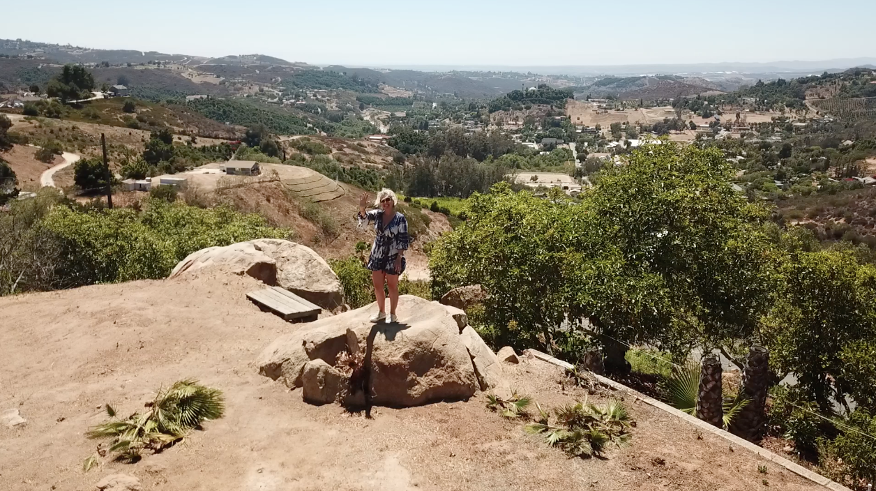 Bonnie Foster standing on top of backyard boulder