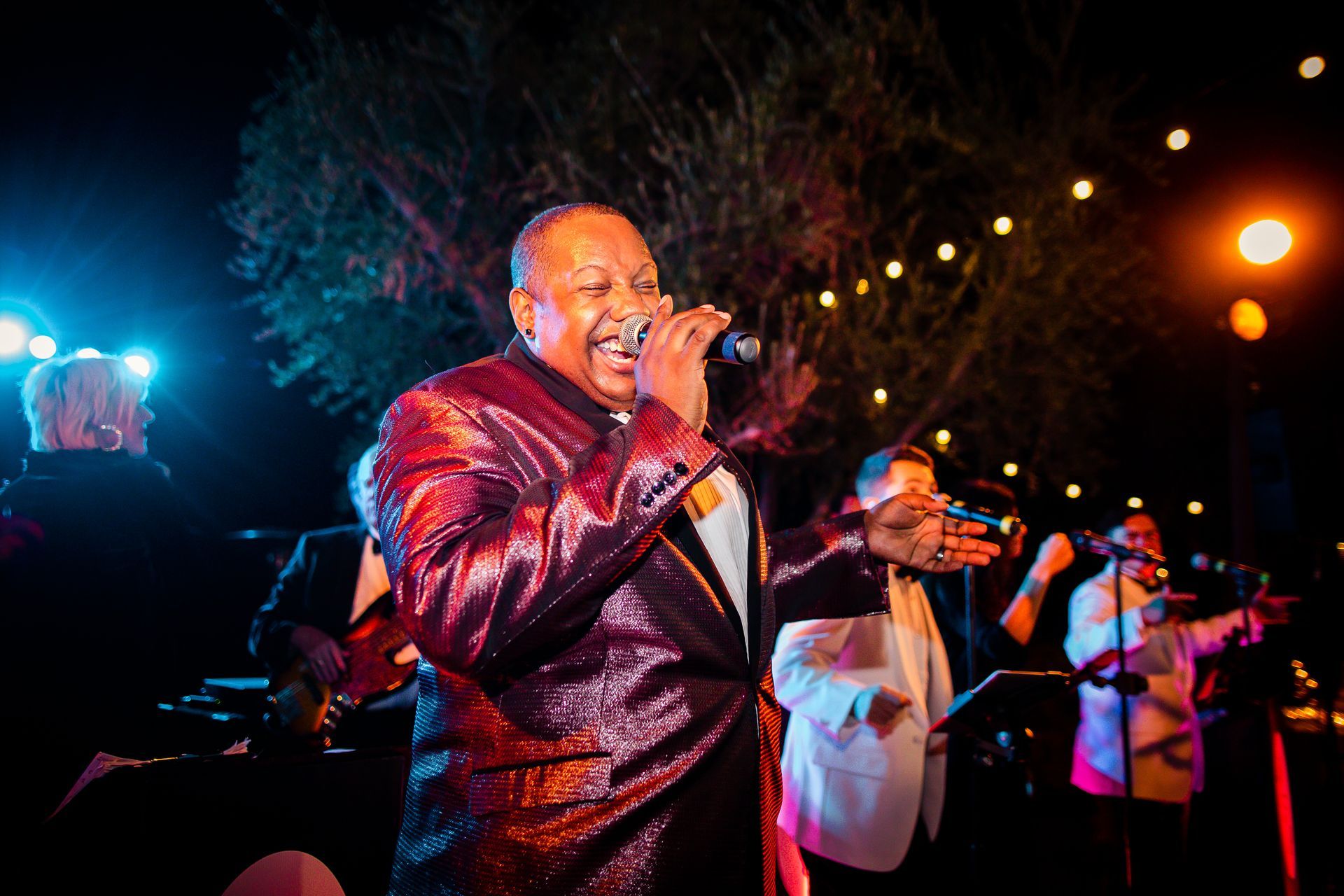 Lead vocalist singing passionately with background singers at wedding