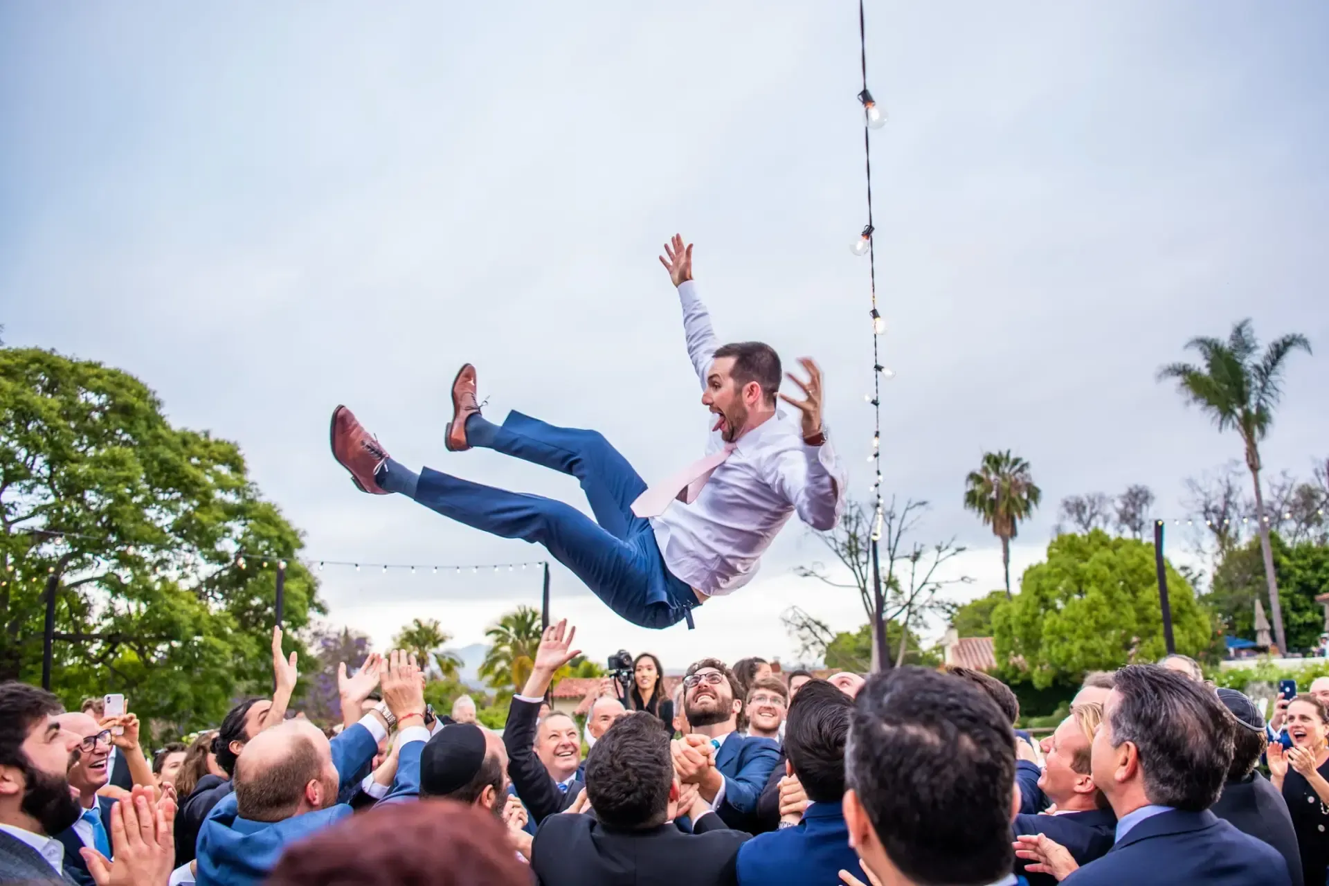 Crowd surfing groom during live band wedding reception