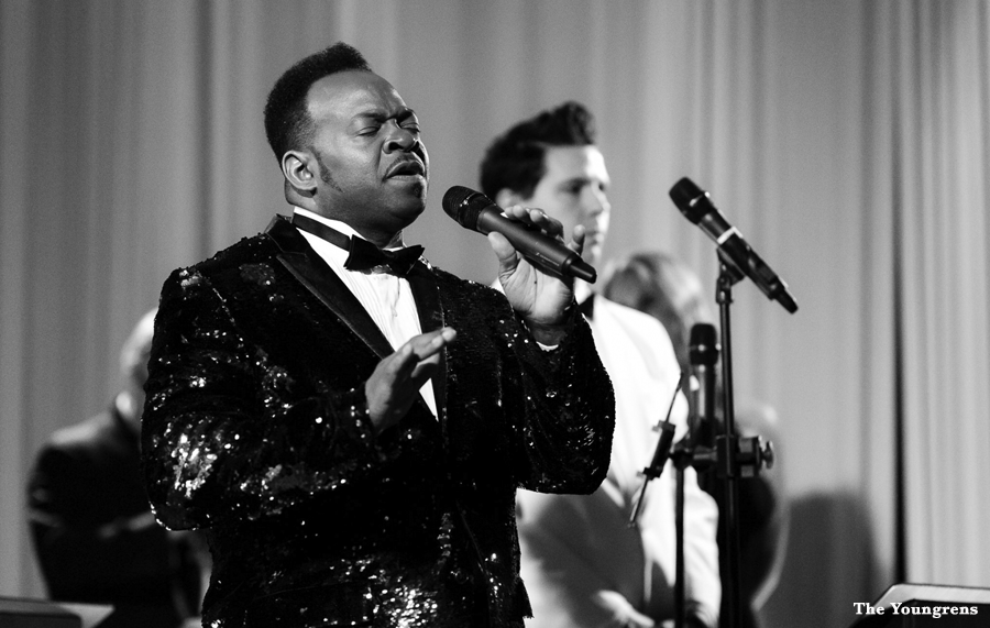 Lead singer and backup singers in black and white performing live