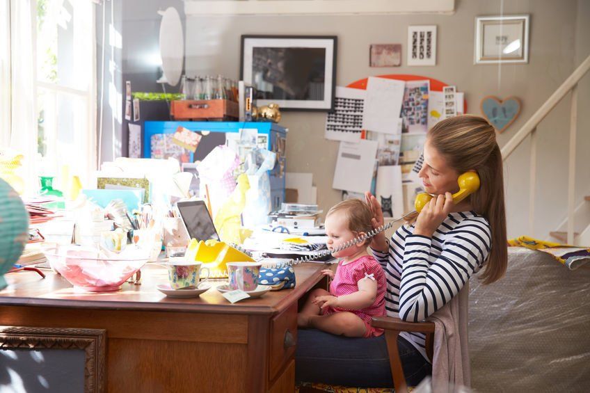 Mother working with daughter on cluttered desk