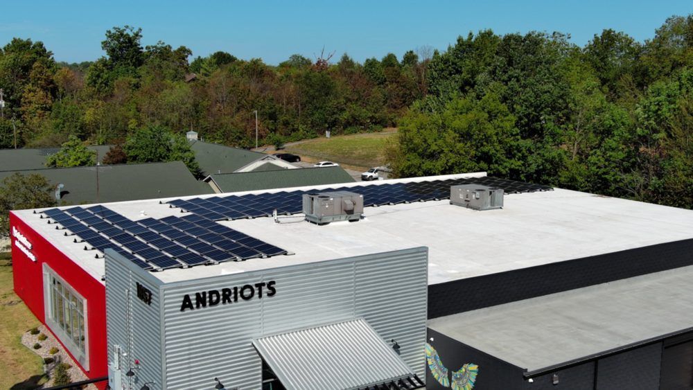 A building with solar panels on the roof, the words 