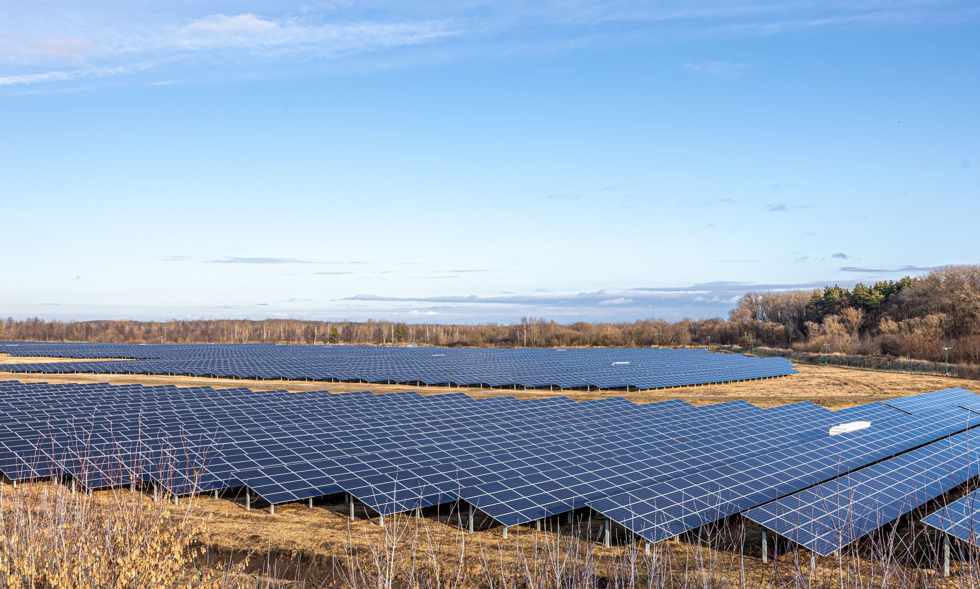 Solar panels in a field under a blue sky, generating clean energy.