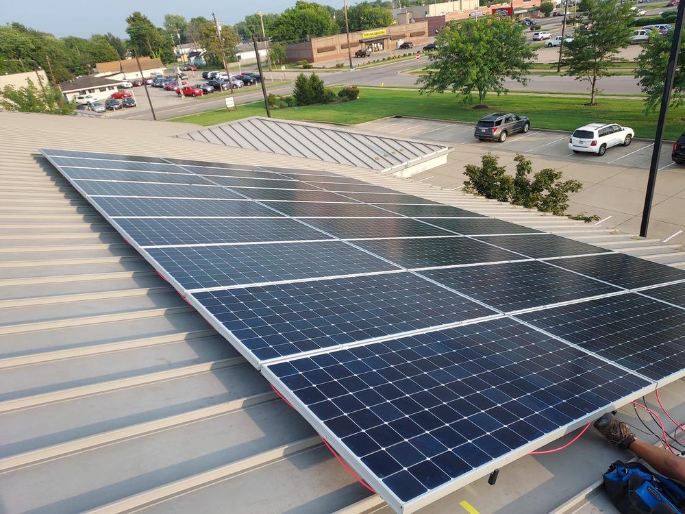 Solar panels installed on a metal roof in a commercial area.