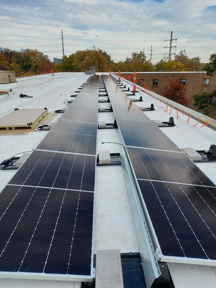 Solar panels installed on a flat commercial rooftop, with visible support structures and safety rails.