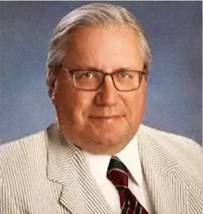 A man in a suit and tie is wearing glasses.