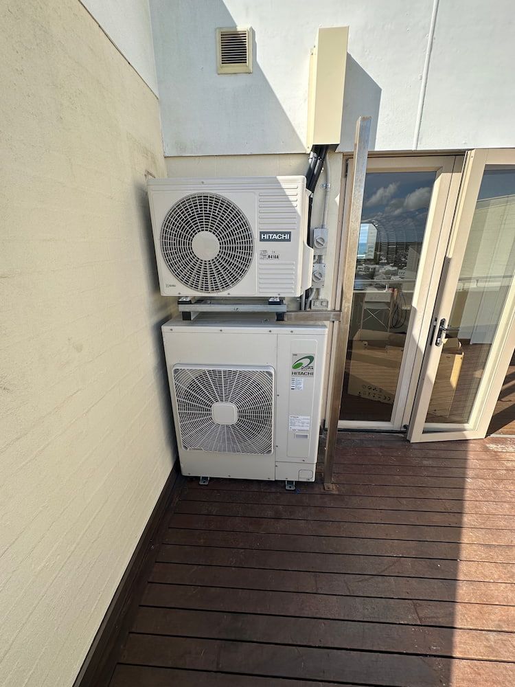 A Large Air Conditioner is Sitting on Top of a Wooden Deck — Comfort Solutions in Buderim, QLD