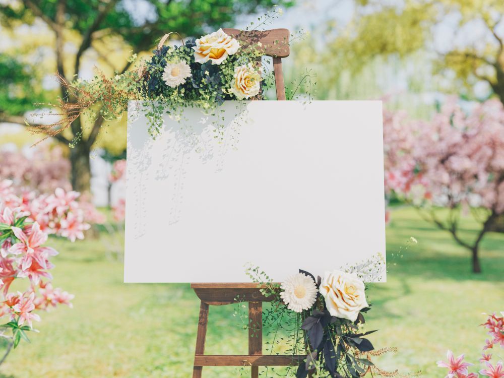 A White Board Is Sitting on a Wooden Easel Decorated With Flowers - Yeppoon Balloons & Party Supplies in Yeppoon, Qld