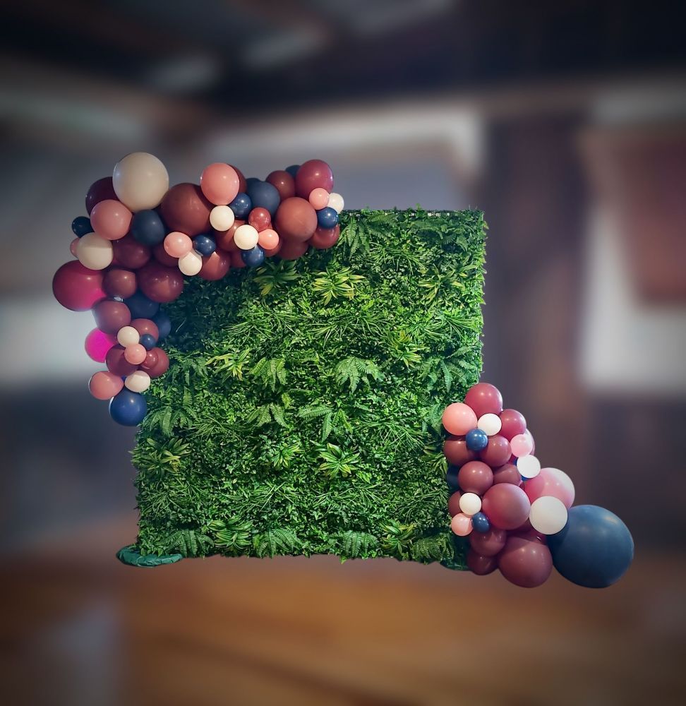 Box-hedge greenery wall with balloons attached