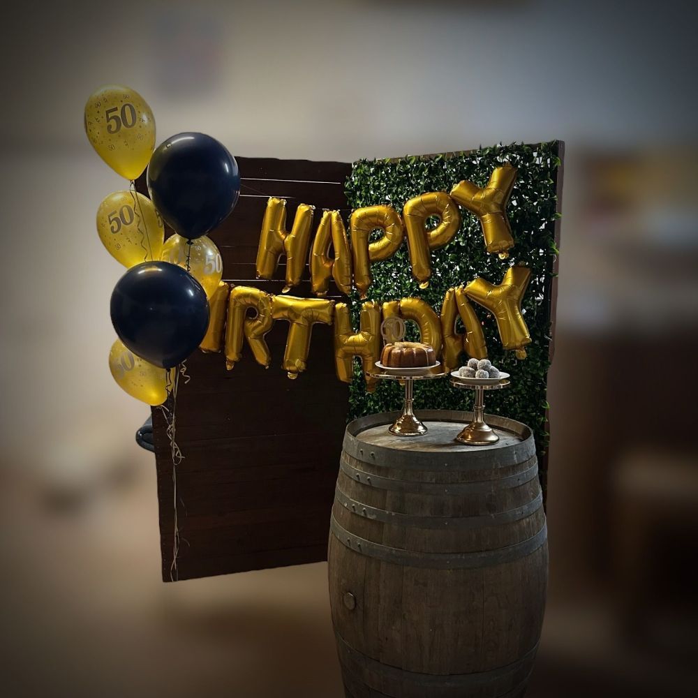 Timber and greenery corner with balloons attached