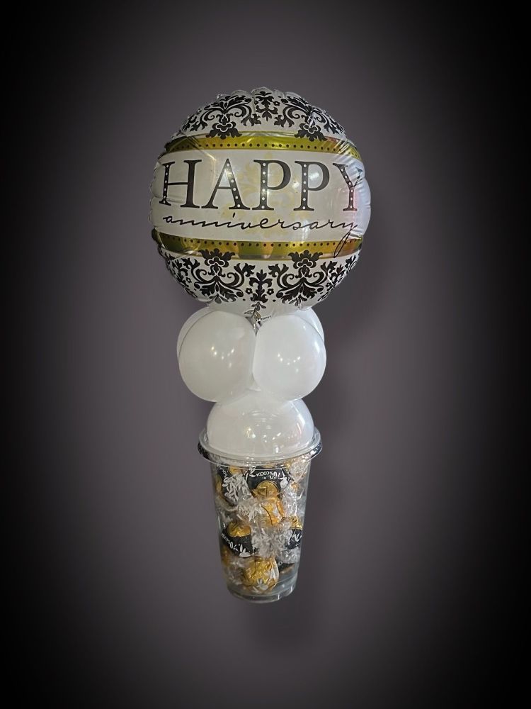 A candy cup with balloons attached