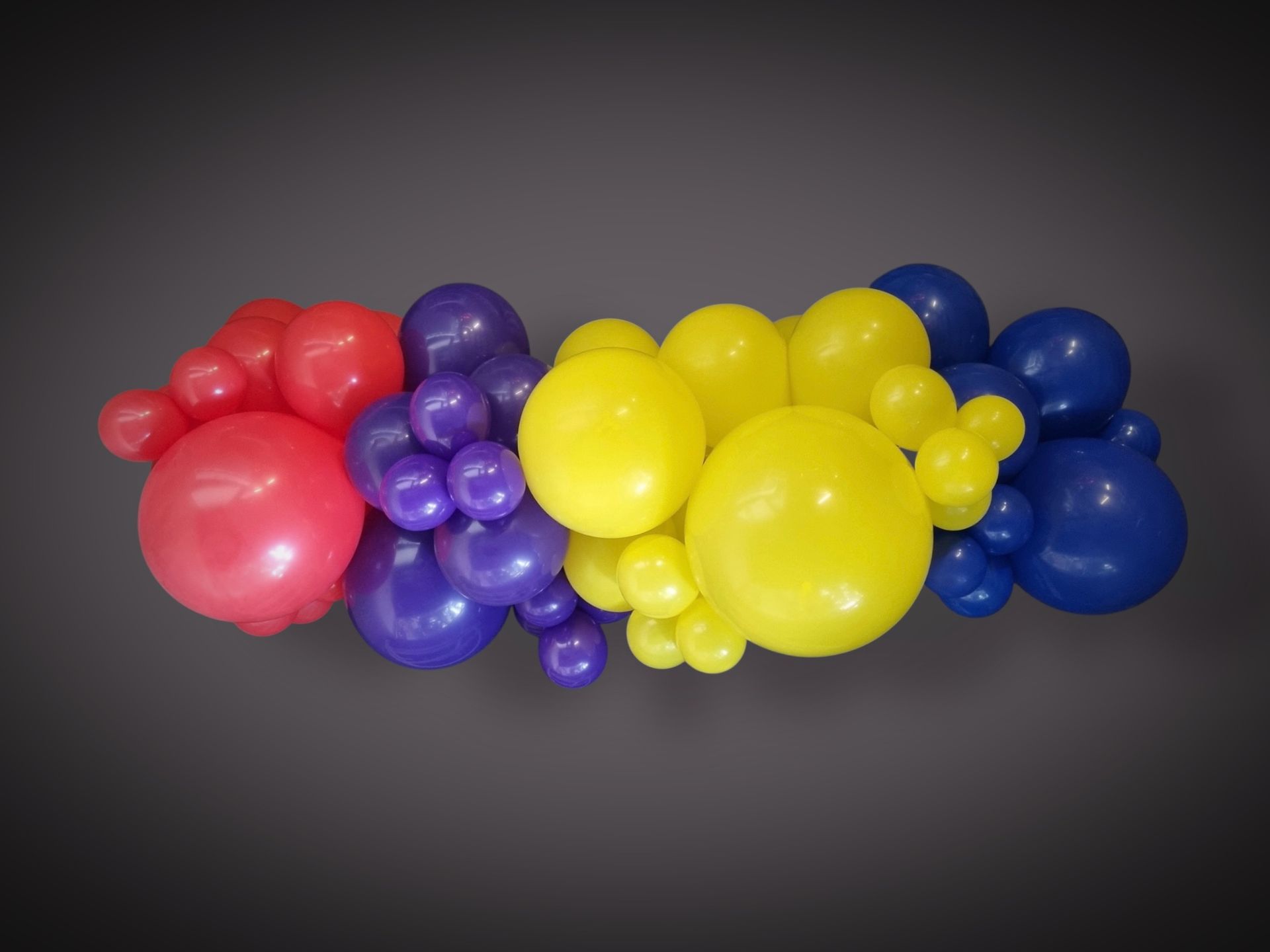 Bundle of red, purple, yellow, and blue balloons