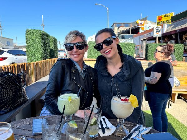 Two women are sitting at a table with drinks.