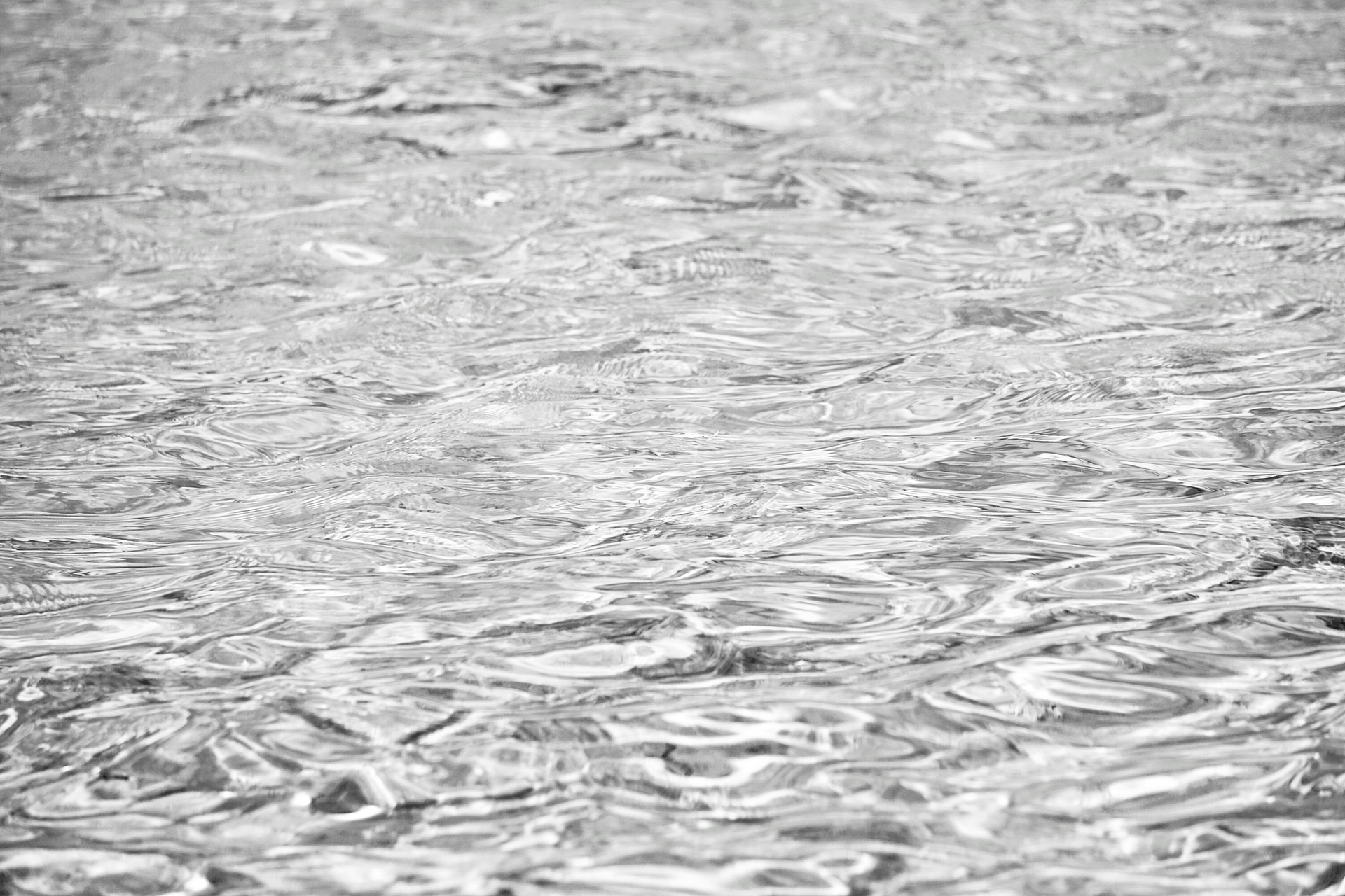 Rippling gray water surface with small waves and reflections