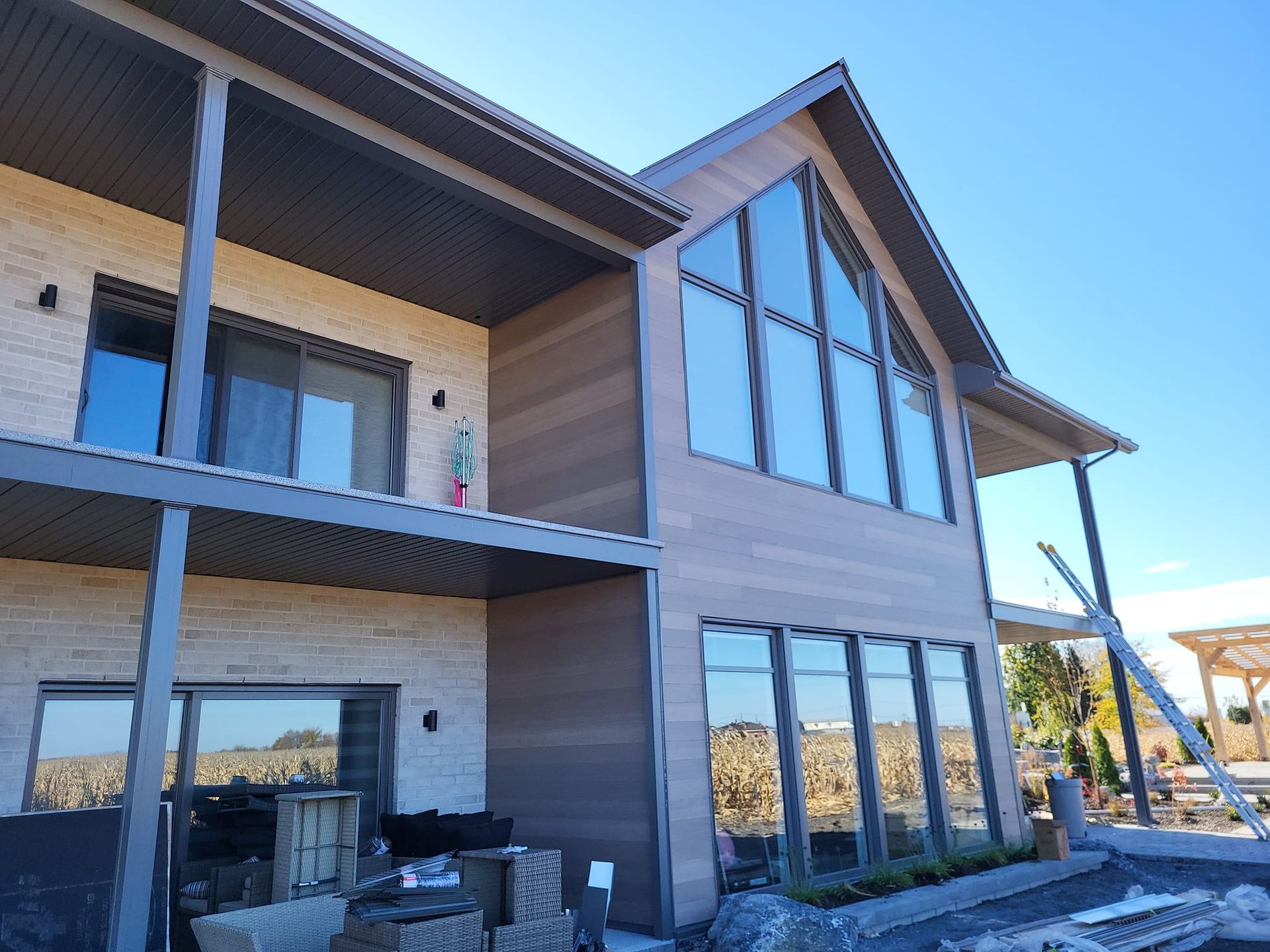 Une grande maison avec beaucoup de fenêtres est en construction.