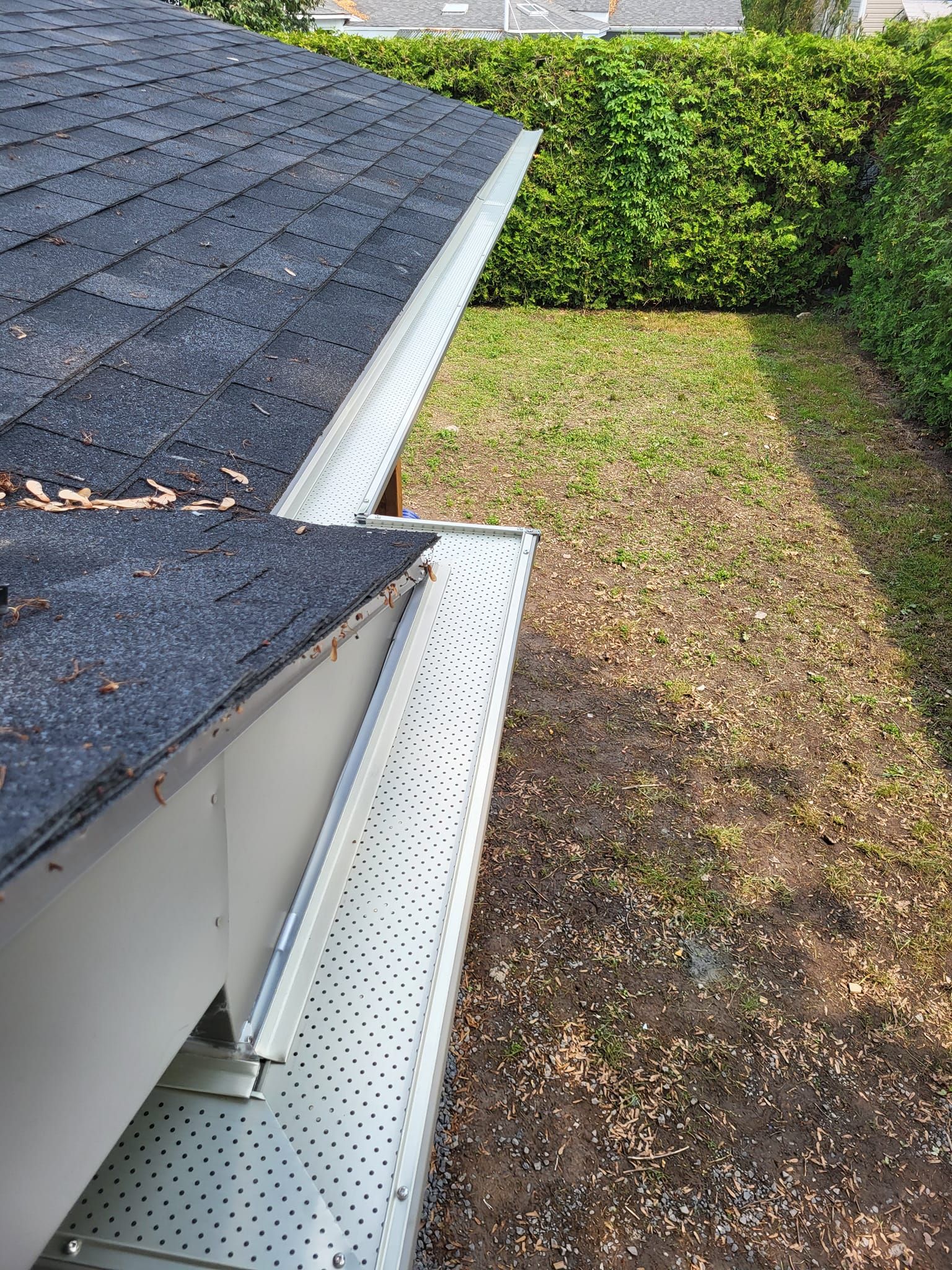 Une gouttière sur le côté d'une maison à côté d'un toit.