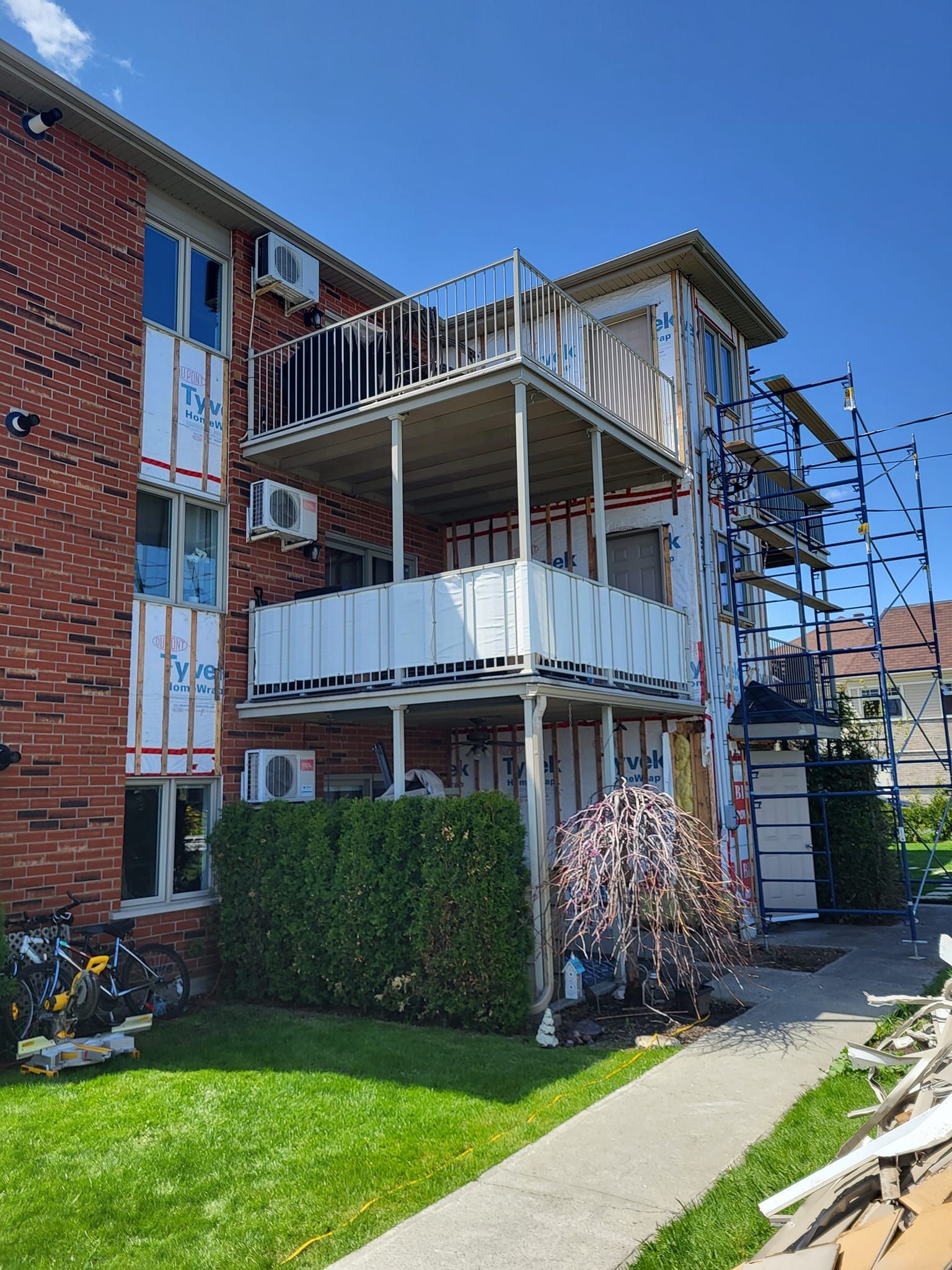 Un immeuble en briques avec balcon est en cours de rénovation.