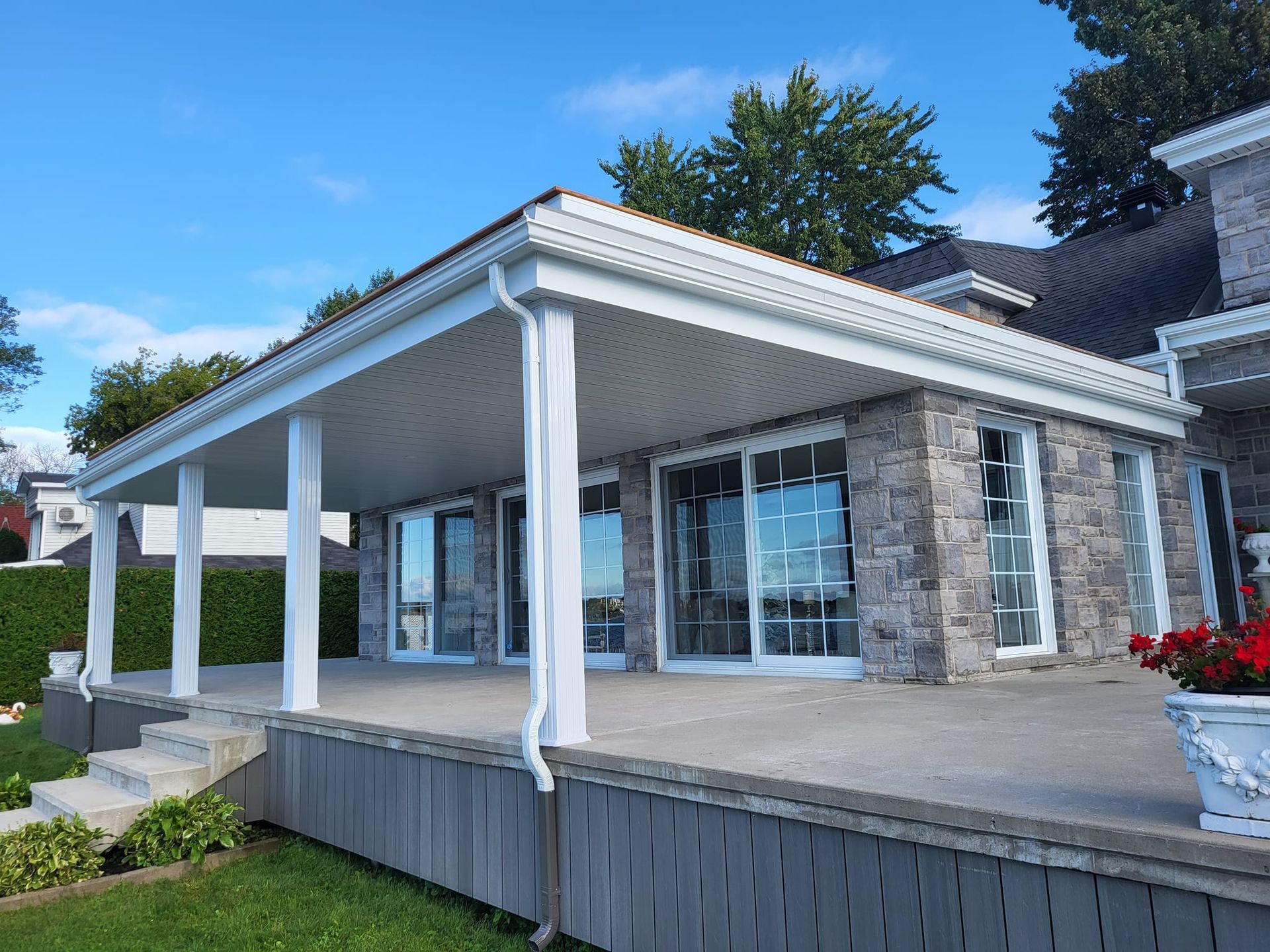 Une grande maison avec un grand porche et beaucoup de fenêtres.