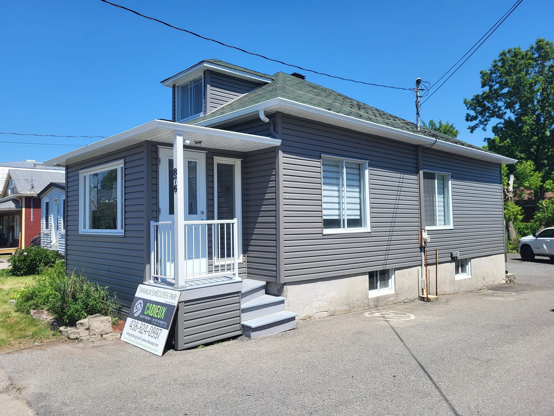 Une petite maison avec un panneau sur le côté indiquant à vendre