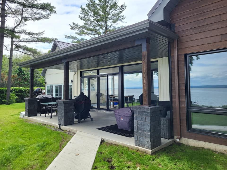 Une maison avec un patio couvert et une vue sur l'eau.