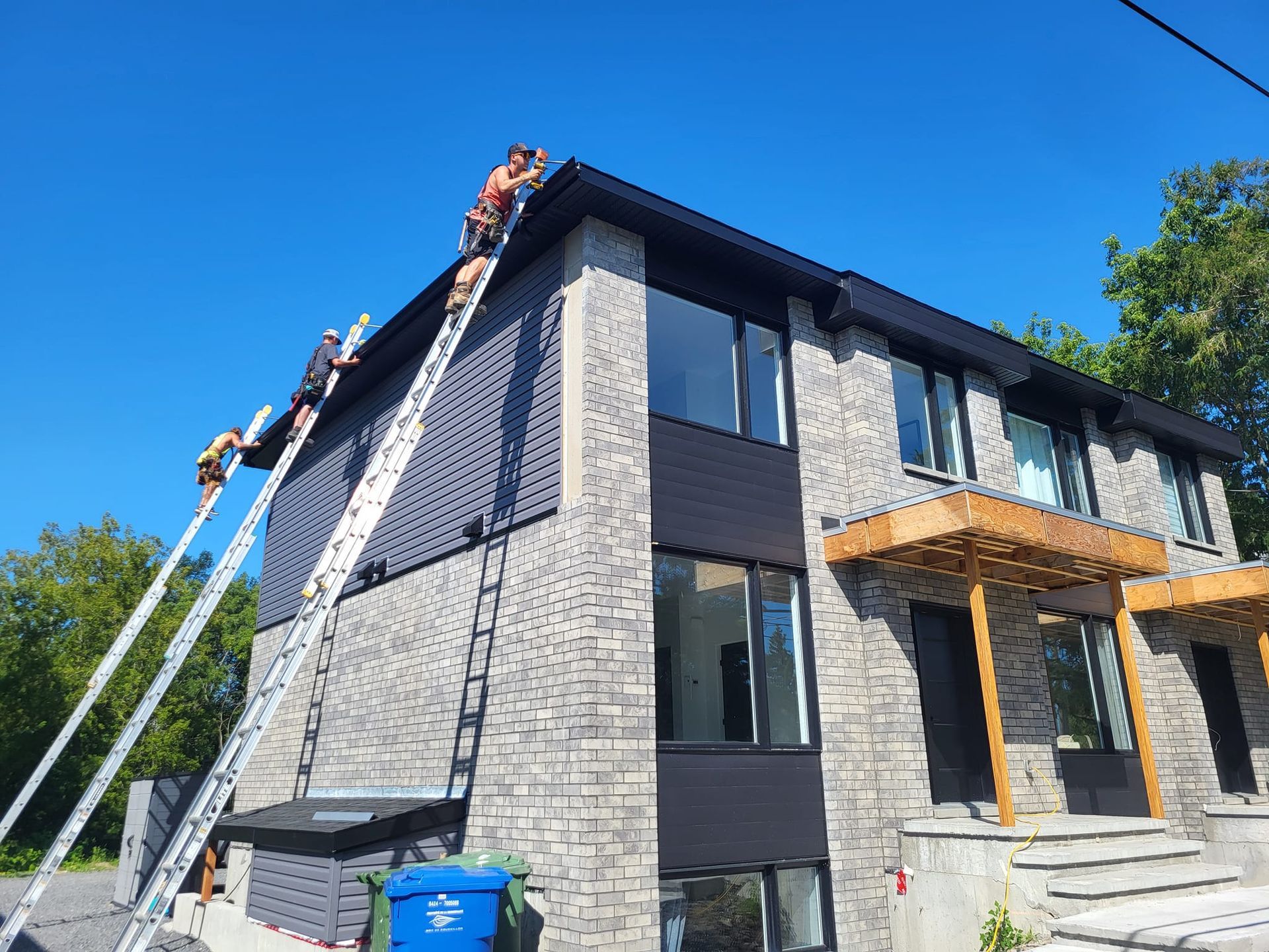 Un groupe de personnes travaille sur le toit d'une maison.