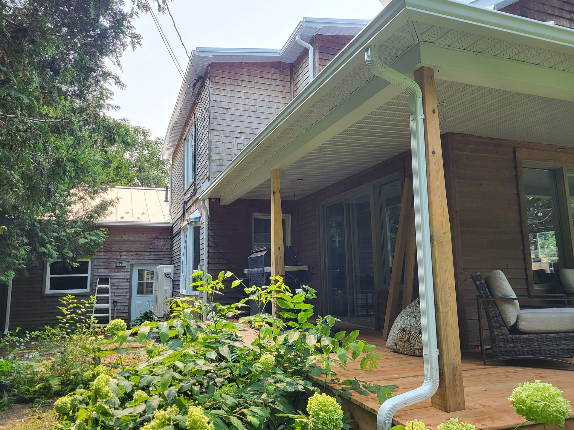 Une maison avec un porche et une gouttière sur le côté.
