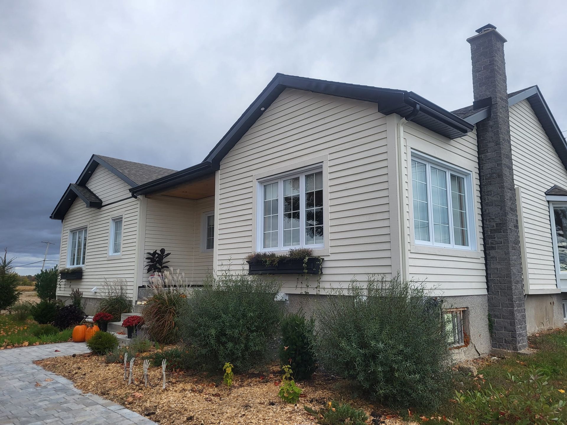 Une maison blanche avec une cheminée sur le côté