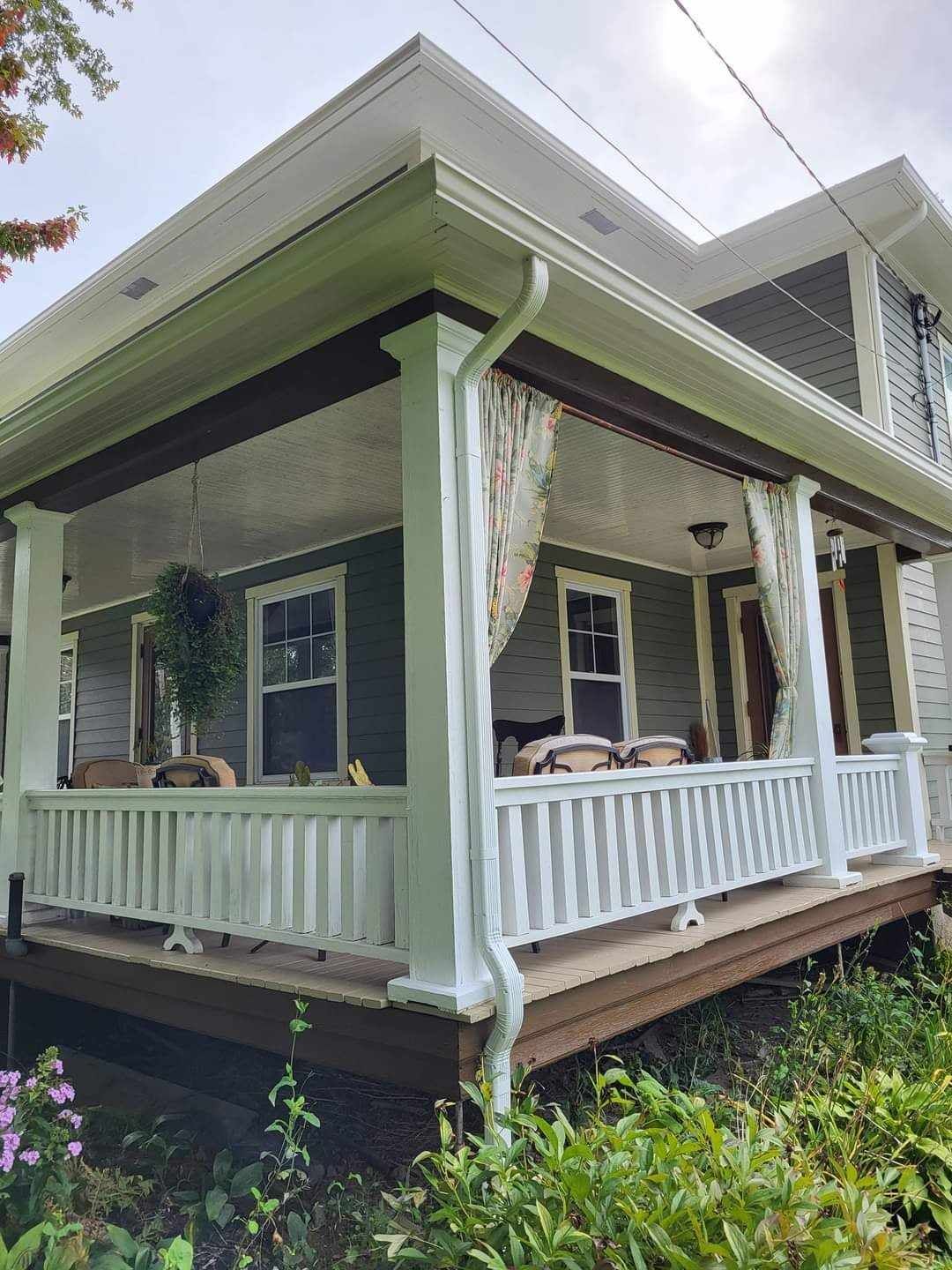 Une maison avec un porche et une balustrade blanche.