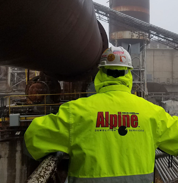 A man wearing a yellow jacket with the word alpine on it