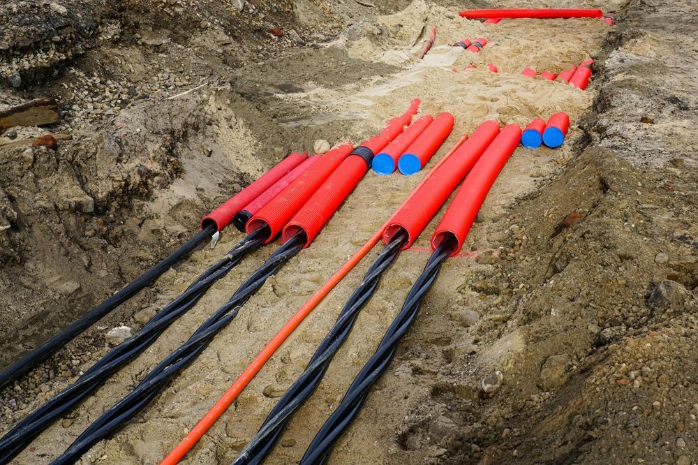 Cap and seal of electrical power cables and utility lines in trench with red conduits and capped pipes