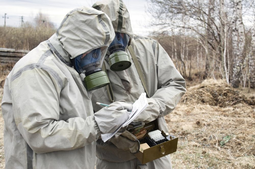 Hazardous Waste Manifest documentation with hazmat team conducting outdoor environmental testing and reviewing regulated waste transport forms