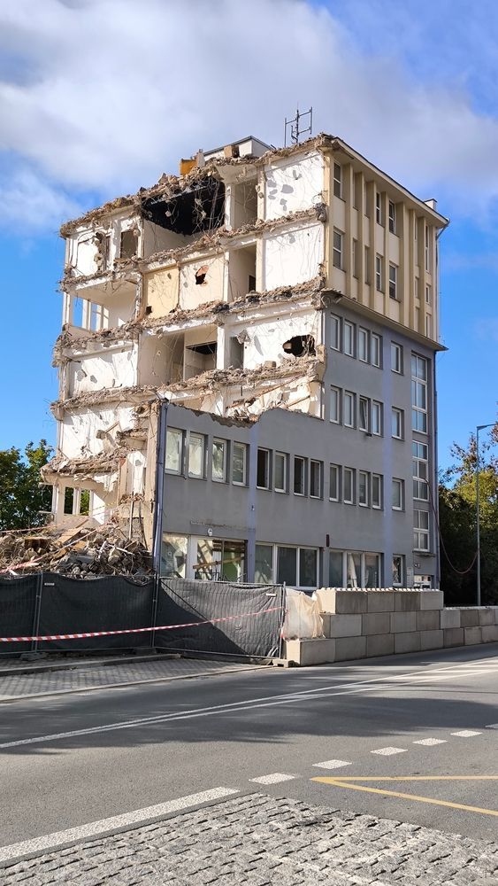 Partially demolished building under demolition, construction site with rubble, urban decay scene, exposed structure, industrial architecture